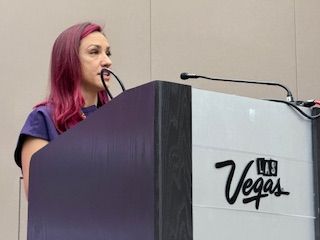 Dr. JenSU speaking at a Las Vegas podium